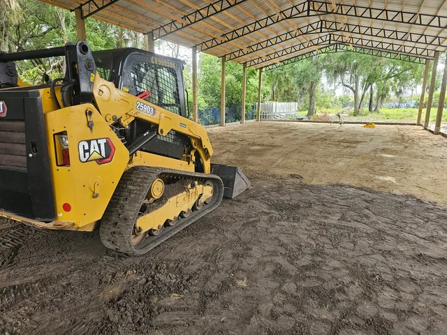 Skid steer grading a building pad